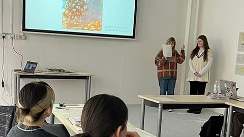 two students presenting their work to the rest of the group